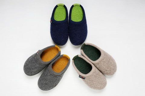 Colorful Haflinger slippers made of pure wool arranged in a circle on the floor.